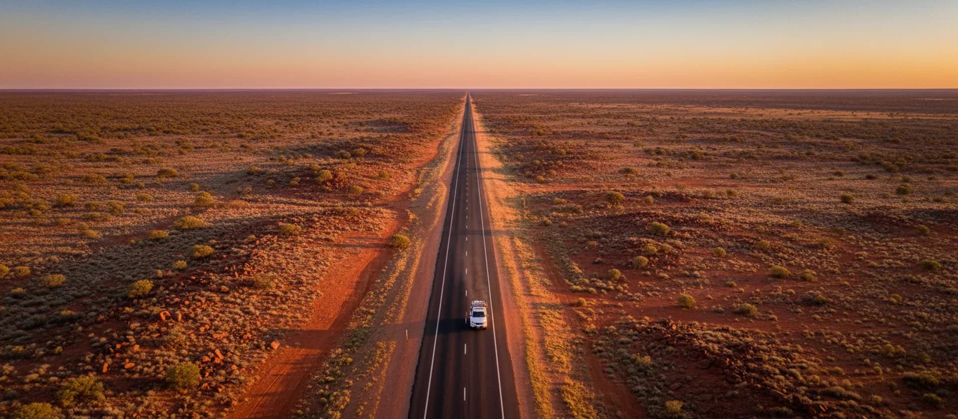 Aerial view of an outback highway crossing red dirt country