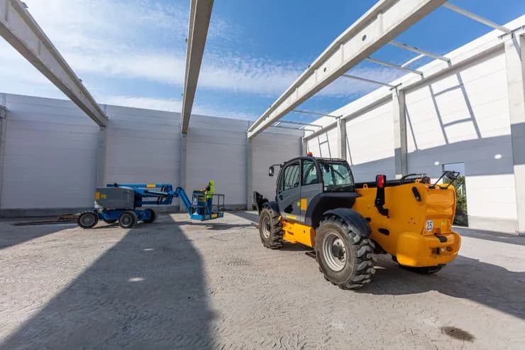 Telehandler and boom lift at a warehouse construction site